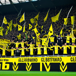 분데스리가 명문 구단 - **Prompt:** A bustling stadium scene in Dortmund, Germany, featuring the "Gelbe Wand" (Yellow Wall) ...